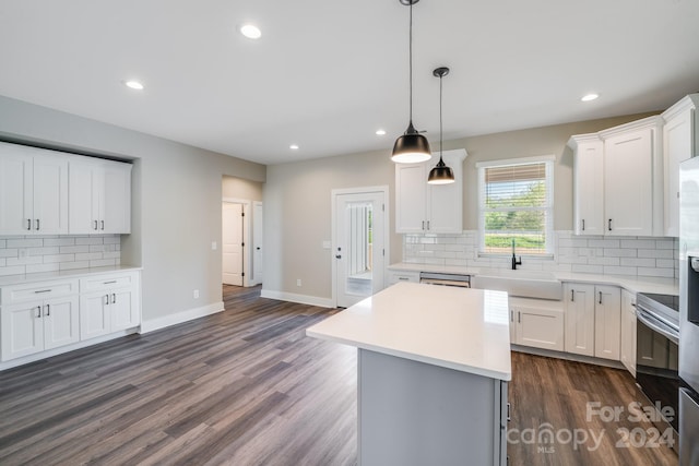 kitchen with a center island, sink, white cabinetry, and dark wood-type flooring