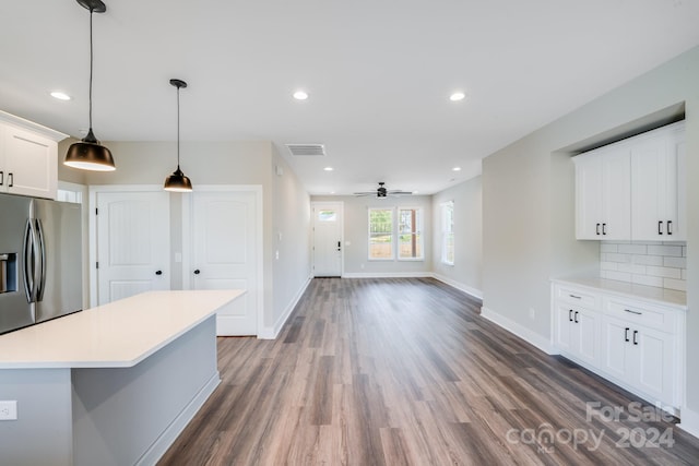 kitchen with white cabinetry, decorative light fixtures, dark hardwood / wood-style flooring, ceiling fan, and stainless steel fridge with ice dispenser