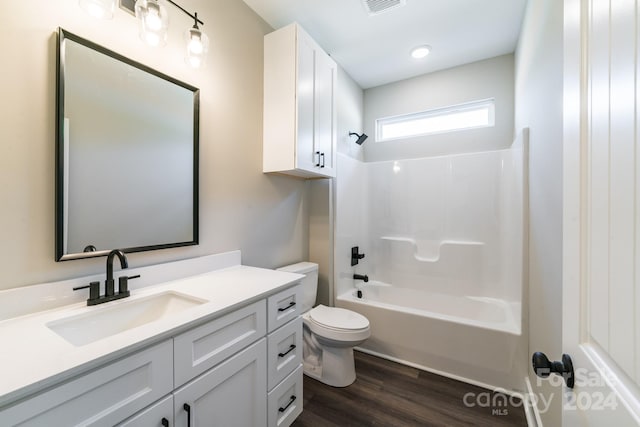 full bathroom featuring vanity, toilet, hardwood / wood-style flooring, and shower / washtub combination