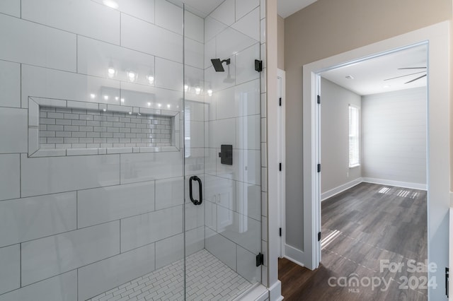 bathroom with ceiling fan, wood-type flooring, and walk in shower