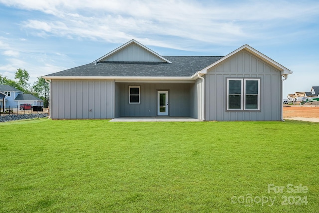 back of house with a lawn and a patio