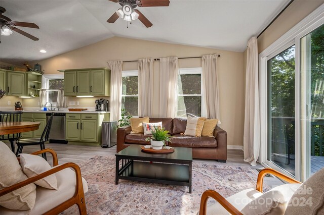 living room with lofted ceiling, plenty of natural light, ceiling fan, and light hardwood / wood-style floors