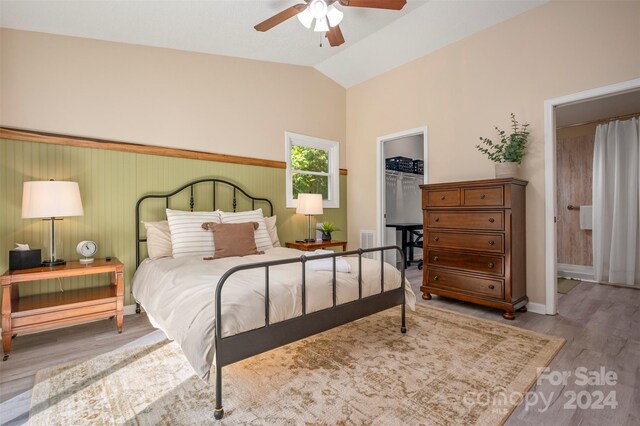 bedroom featuring a closet, vaulted ceiling, a spacious closet, and hardwood / wood-style flooring