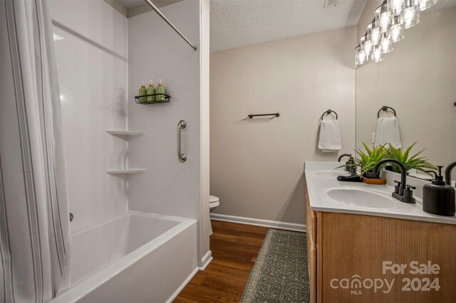 full bathroom with a textured ceiling, vanity, shower / tub combo with curtain, wood-type flooring, and toilet