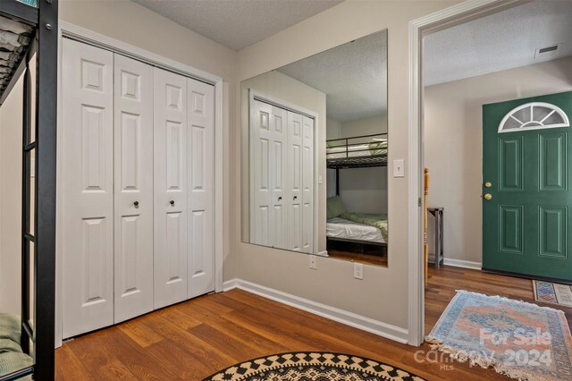 foyer entrance with hardwood / wood-style flooring and a textured ceiling