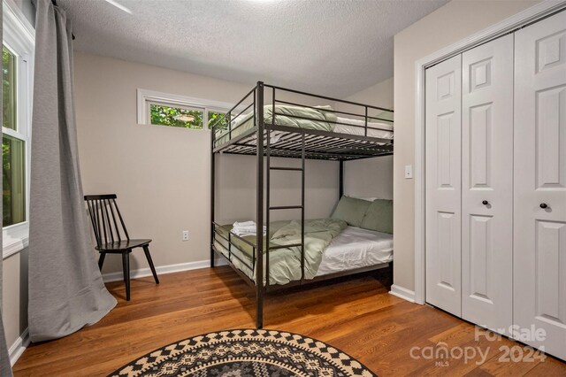 bedroom featuring a textured ceiling, hardwood / wood-style floors, and a closet