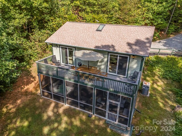 back of property with a sunroom and a deck