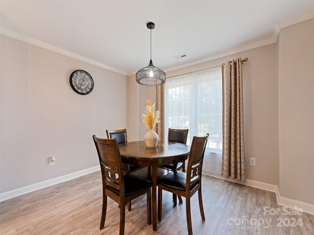 dining space with crown molding and light hardwood / wood-style flooring