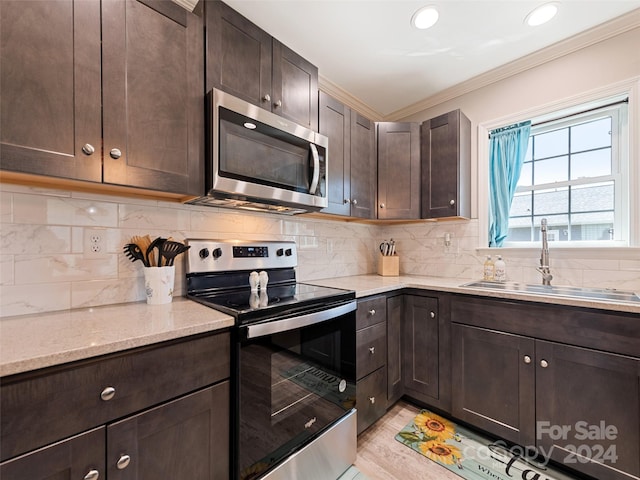 kitchen featuring ornamental molding, stainless steel appliances, sink, and dark brown cabinetry