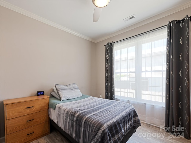 bedroom with ceiling fan, ornamental molding, and hardwood / wood-style flooring