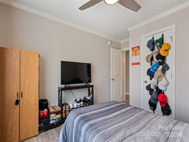 bedroom with ornamental molding, wood-type flooring, and ceiling fan