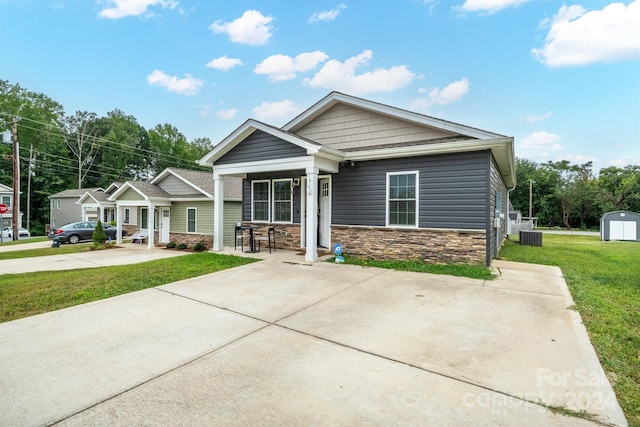 craftsman inspired home featuring a storage unit, a front lawn, and central air condition unit