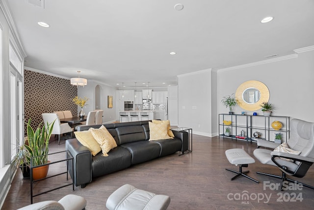 living room featuring crown molding, wood-type flooring, and an inviting chandelier