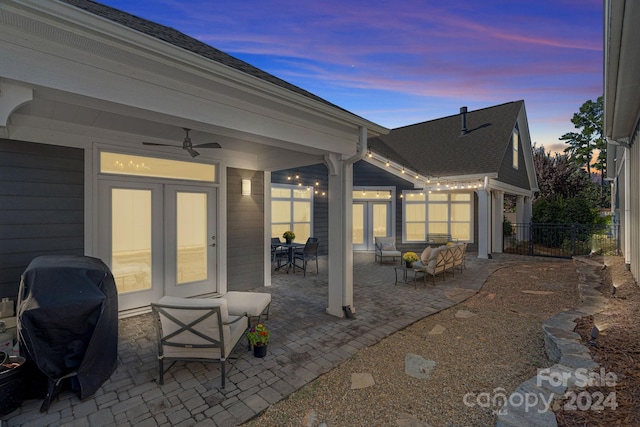 patio terrace at dusk with ceiling fan, grilling area, and an outdoor hangout area