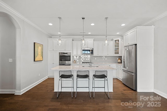 kitchen featuring white cabinetry, hanging light fixtures, a center island with sink, and appliances with stainless steel finishes