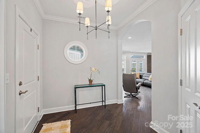 foyer featuring ornamental molding, dark wood-type flooring, and a notable chandelier