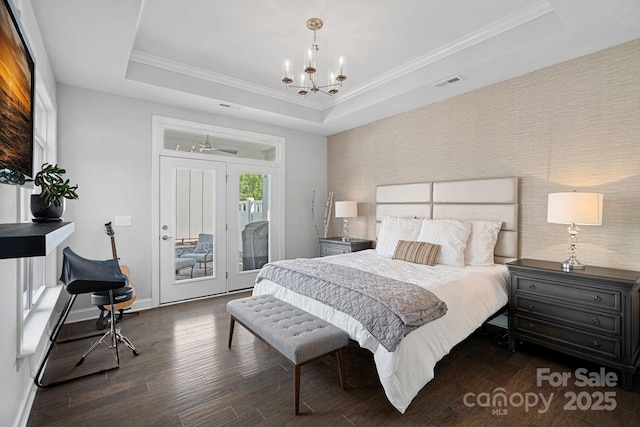 bedroom with crown molding, access to outside, dark hardwood / wood-style flooring, a raised ceiling, and a notable chandelier