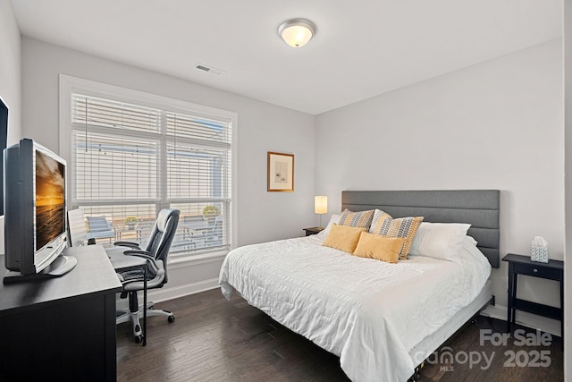 bedroom with dark hardwood / wood-style floors