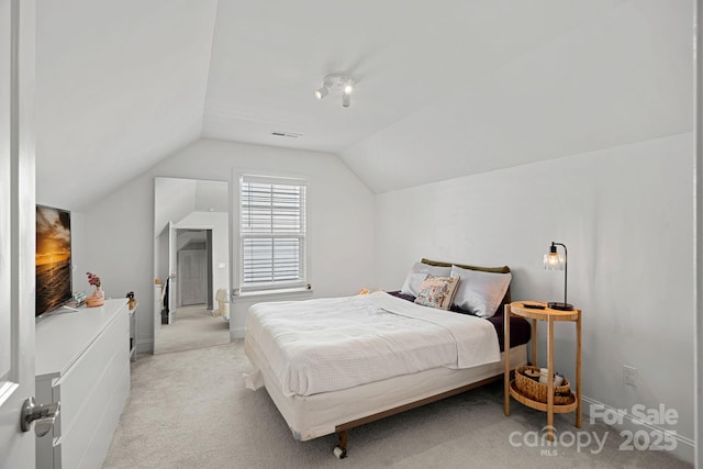 carpeted bedroom with lofted ceiling