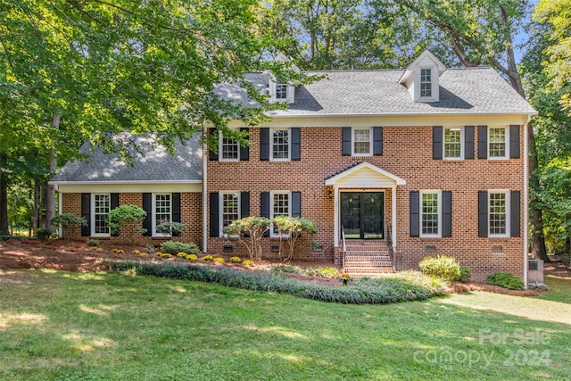 colonial inspired home featuring a front yard and central AC unit