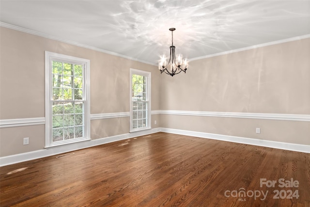 spare room with ornamental molding, a notable chandelier, and wood-type flooring