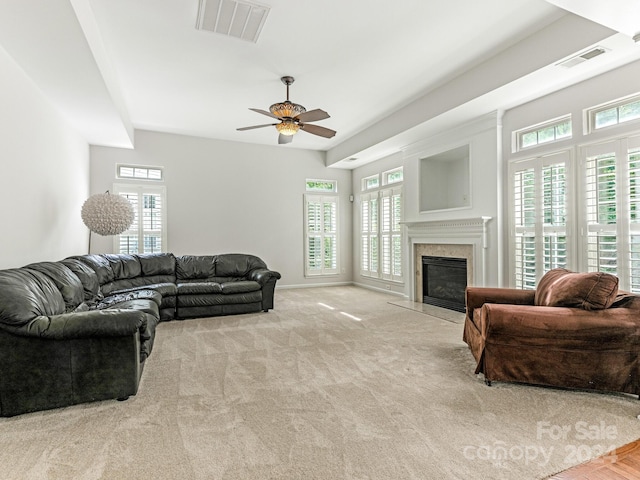 living room with ceiling fan, light colored carpet, and a premium fireplace