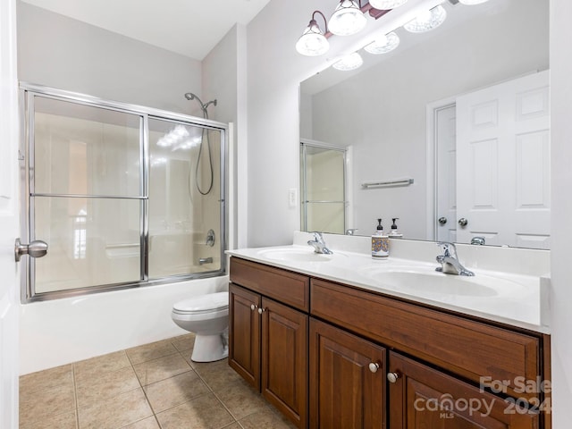 full bathroom featuring tile patterned floors, toilet, combined bath / shower with glass door, and vanity