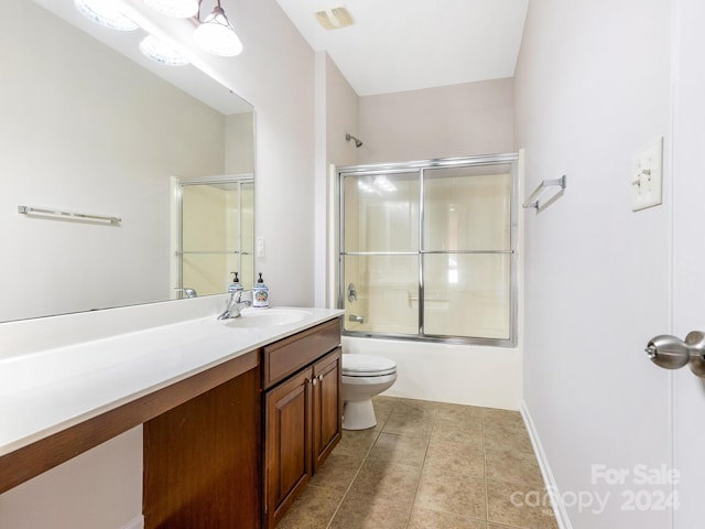 full bathroom featuring shower / bath combination with glass door, vanity, toilet, and tile patterned floors