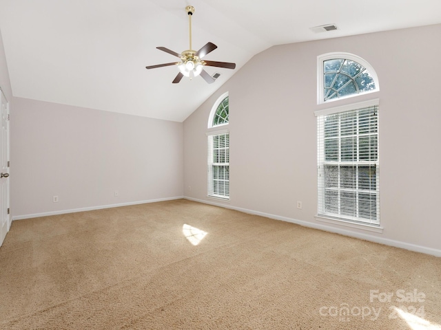 unfurnished room featuring lofted ceiling, plenty of natural light, ceiling fan, and carpet