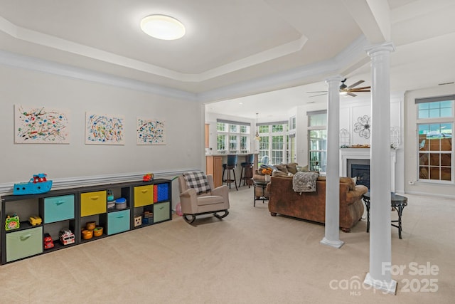 interior space featuring ceiling fan, a raised ceiling, and ornamental molding