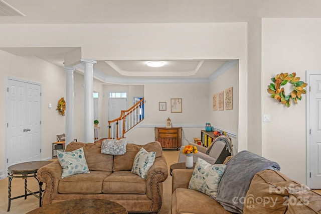 living room with a raised ceiling and crown molding