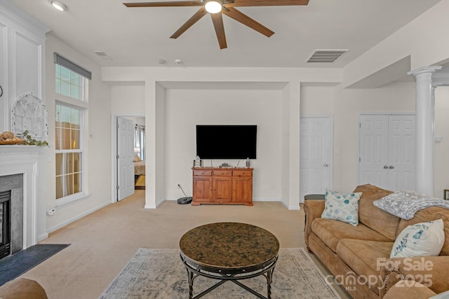 carpeted living room with ceiling fan and ornate columns