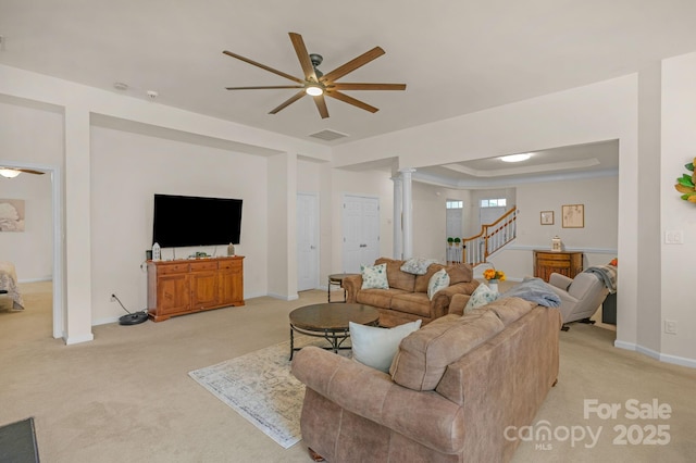 carpeted living room featuring a tray ceiling, ornate columns, and ceiling fan