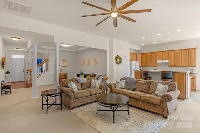 living room featuring ornate columns and ceiling fan