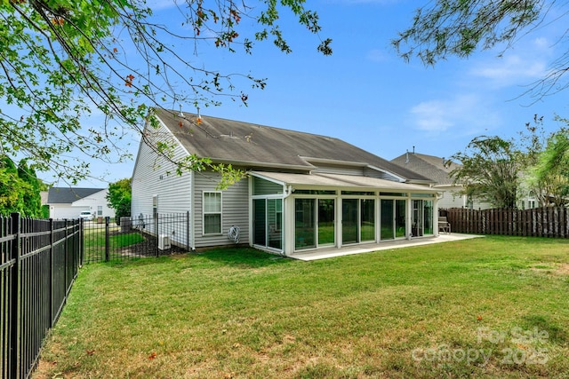 rear view of house featuring a sunroom and a yard