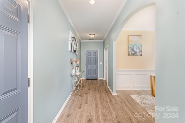 hallway with crown molding and light wood-type flooring