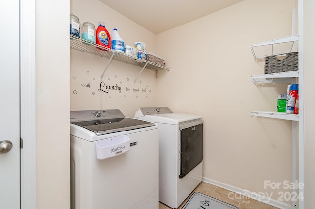 laundry room with separate washer and dryer and light tile patterned flooring