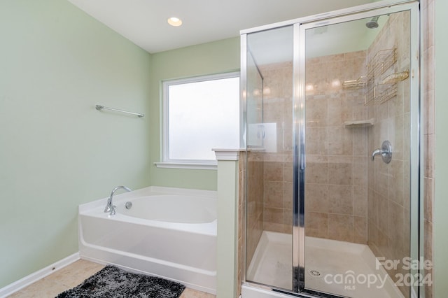 bathroom featuring tile patterned flooring and separate shower and tub