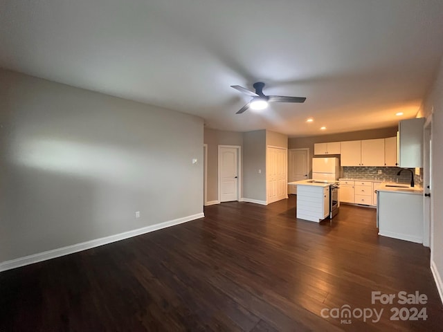 kitchen with dark hardwood / wood-style flooring, sink, a center island, ceiling fan, and white cabinets