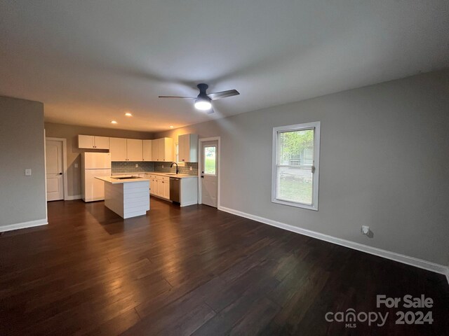 unfurnished living room featuring dark hardwood / wood-style flooring, sink, and ceiling fan