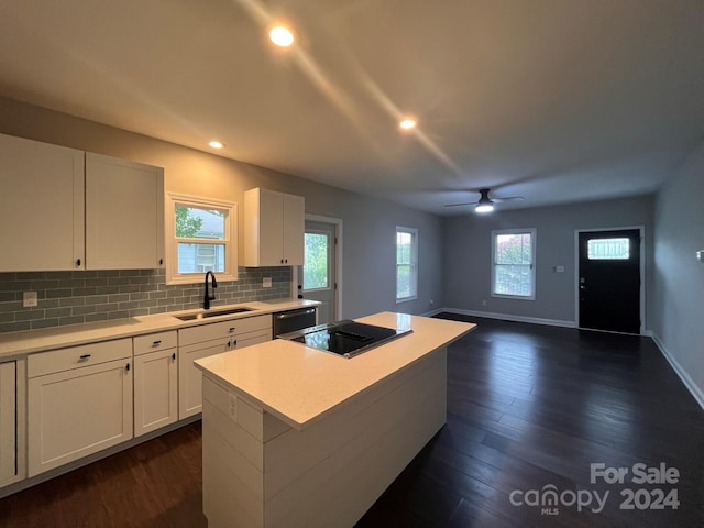 kitchen featuring a center island, white cabinetry, sink, black appliances, and ceiling fan