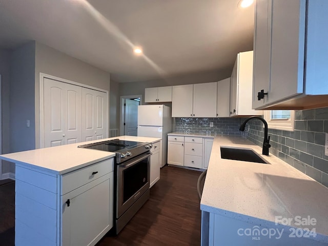 kitchen with a kitchen island, dark hardwood / wood-style flooring, sink, white cabinetry, and electric stove