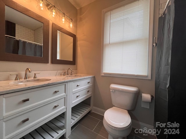 bathroom with tile patterned flooring, vanity, and toilet