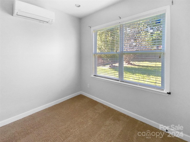 unfurnished room with a wall unit AC and carpet floors