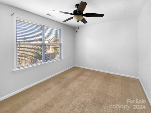 carpeted spare room with ceiling fan