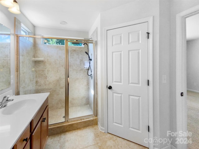 bathroom featuring vanity, a shower with shower door, and tile patterned flooring