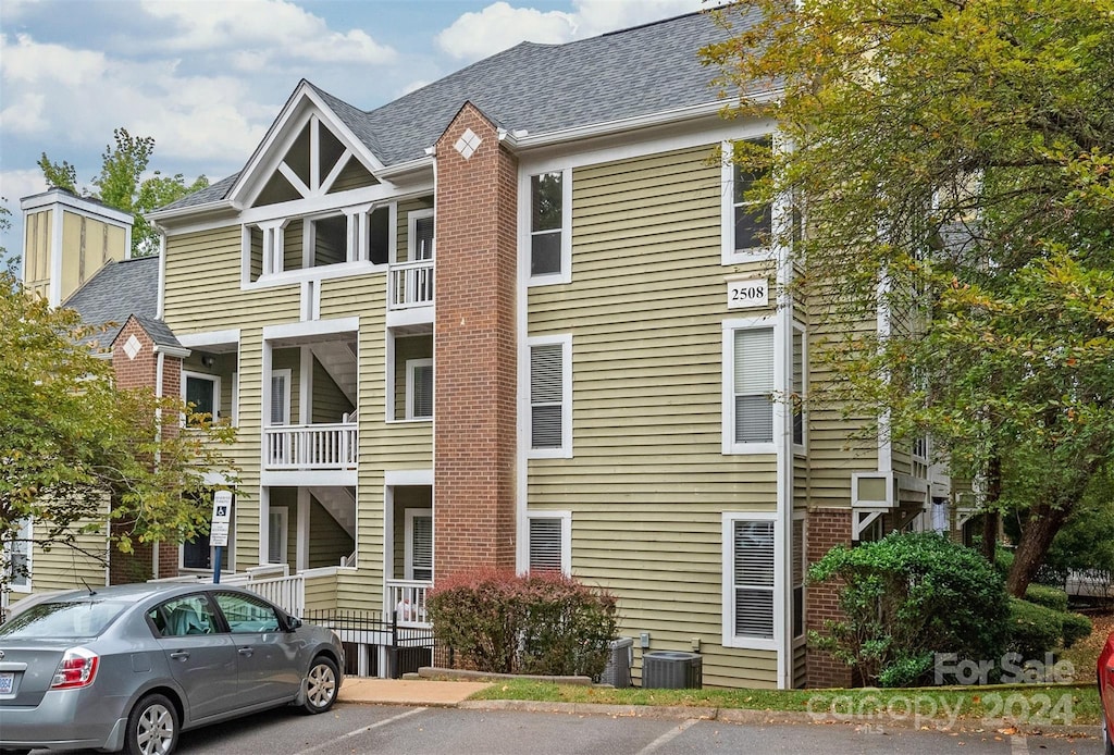 view of front of house featuring a balcony and central AC unit