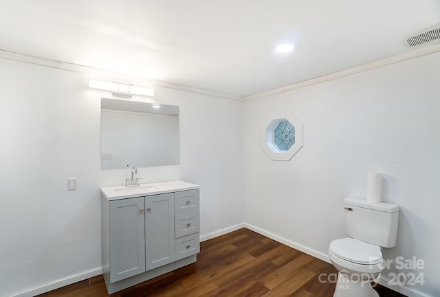 bathroom with vanity, toilet, and hardwood / wood-style flooring