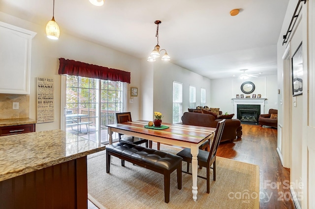 dining room with ceiling fan, a barn door, and dark hardwood / wood-style floors