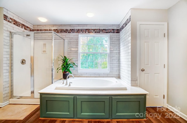 bathroom featuring hardwood / wood-style floors and plus walk in shower